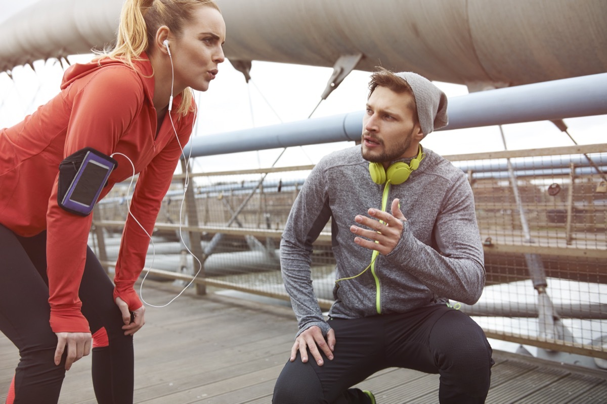 Male and female taking a break while on a run outside