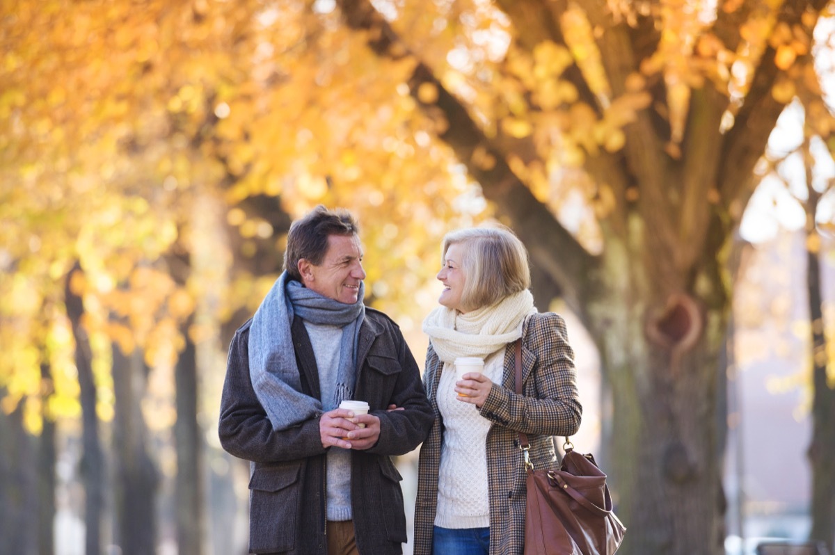 man and woman walking through town in autumn