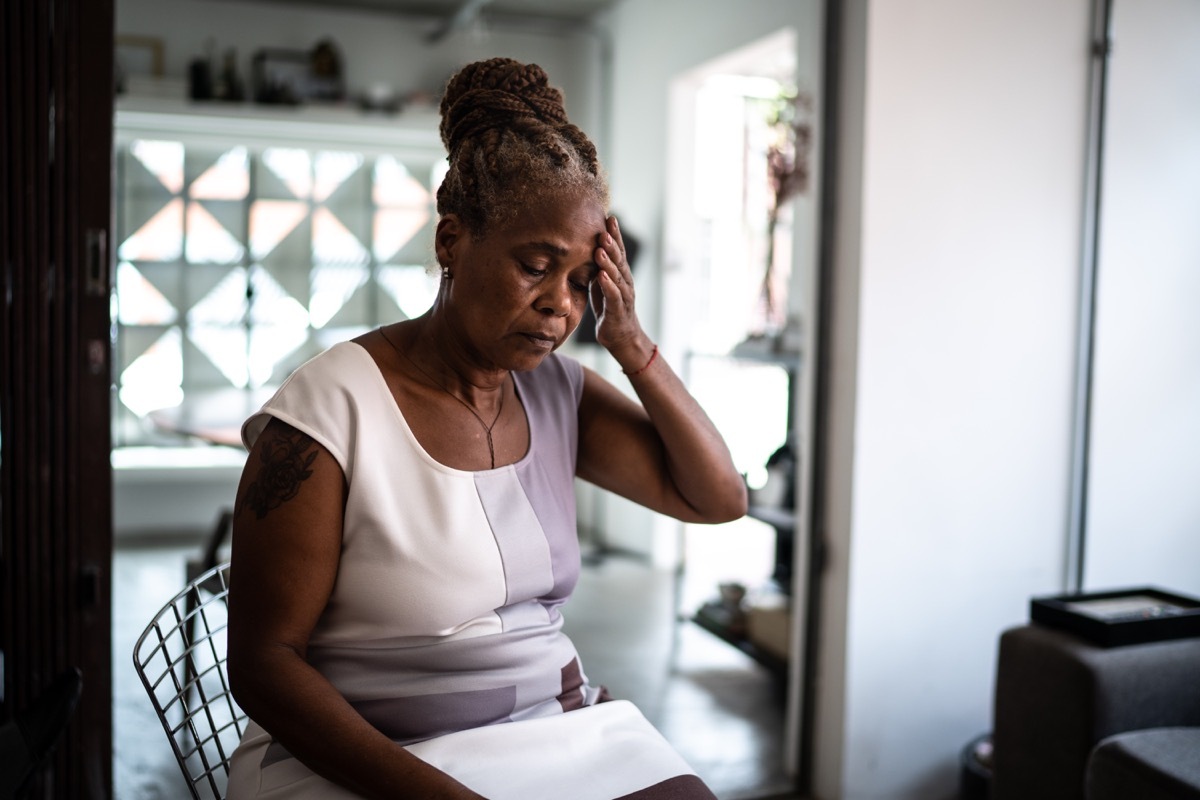 Mature woman with headache at home