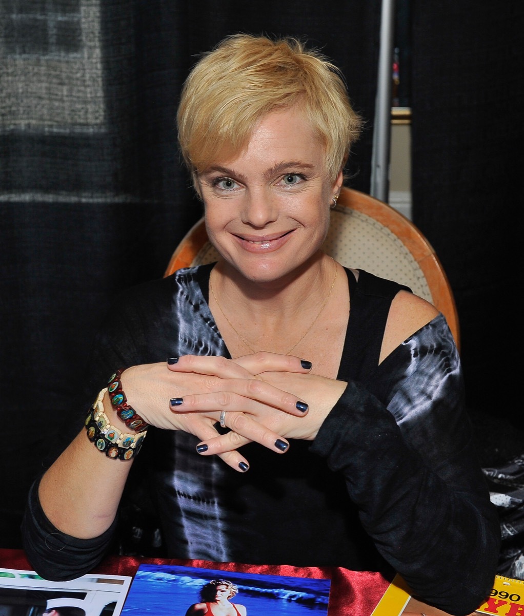 Erika Eleniak in black tie-dye shirt sitting down