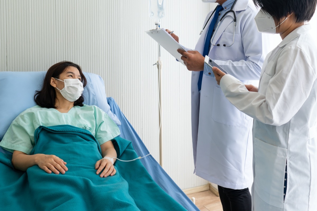 Doctors inspecting patient in hospital.