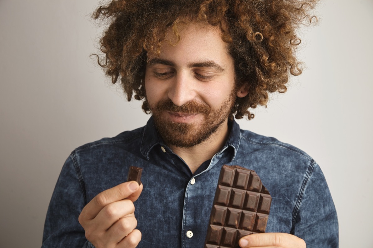 Man eating squares of chocolate