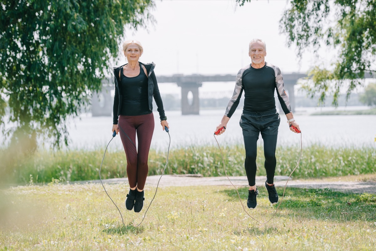 Two adults doing jump rope in the park