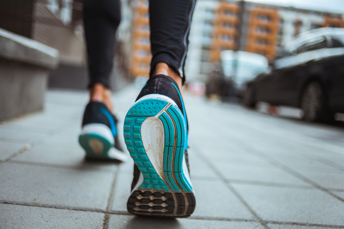 closeup shot of runner's shoes on sidewalk