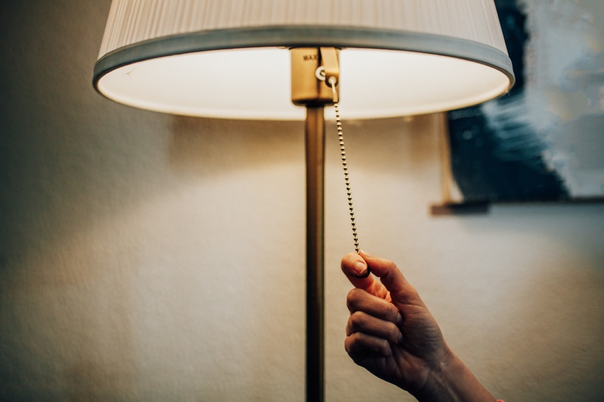 close up of hand reaching off to turn off a lamp