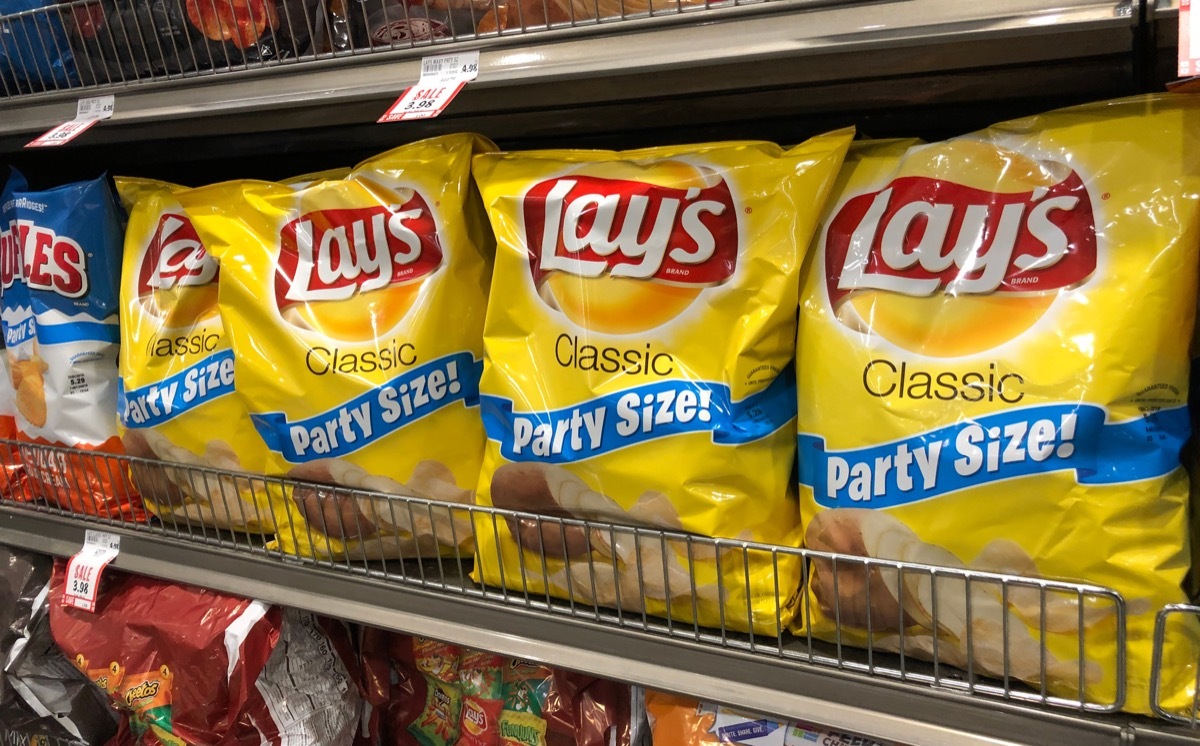 Bags of Lay's brand potato chips snacks at a supermarket shelf