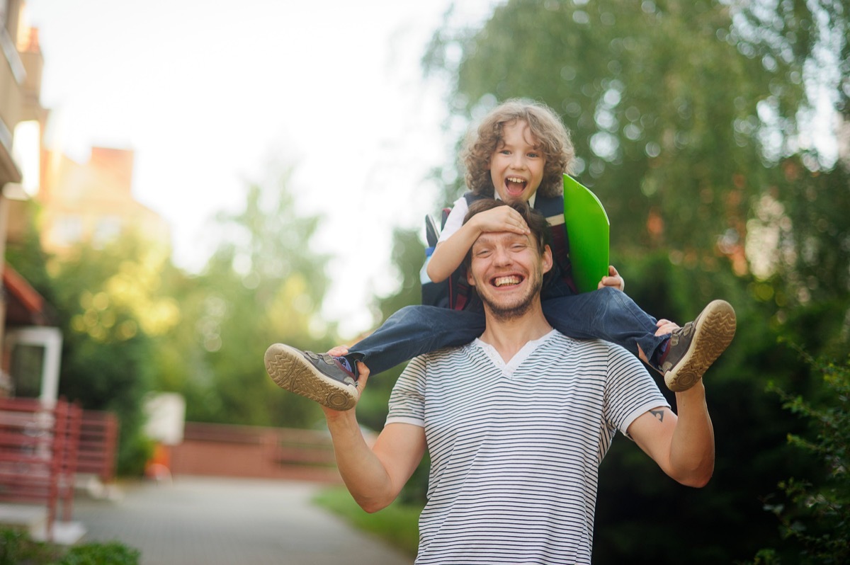 father giving his son a shoulder ride while telling dad jokes