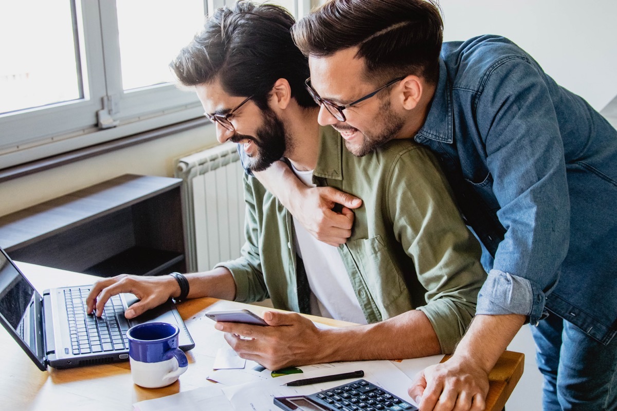 gay couple spending time together at their home on the computer