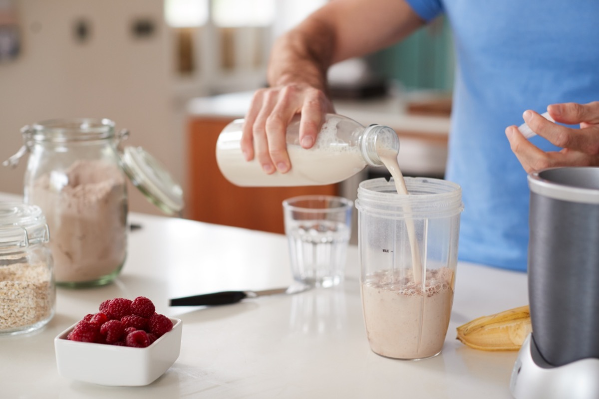 Close Up Of Man Making Protein Shake After Exercise At Home