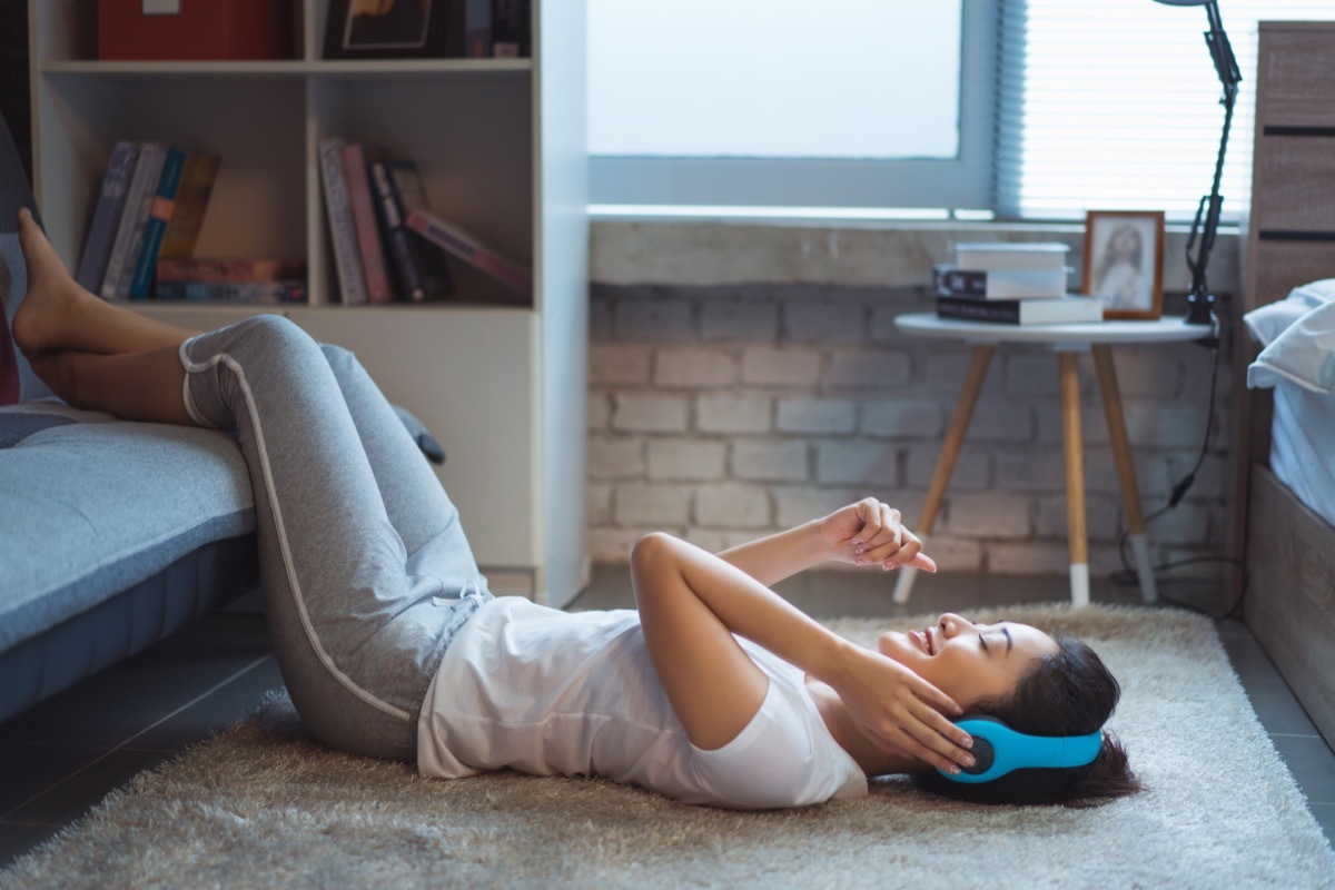 asian woman listening to music at home