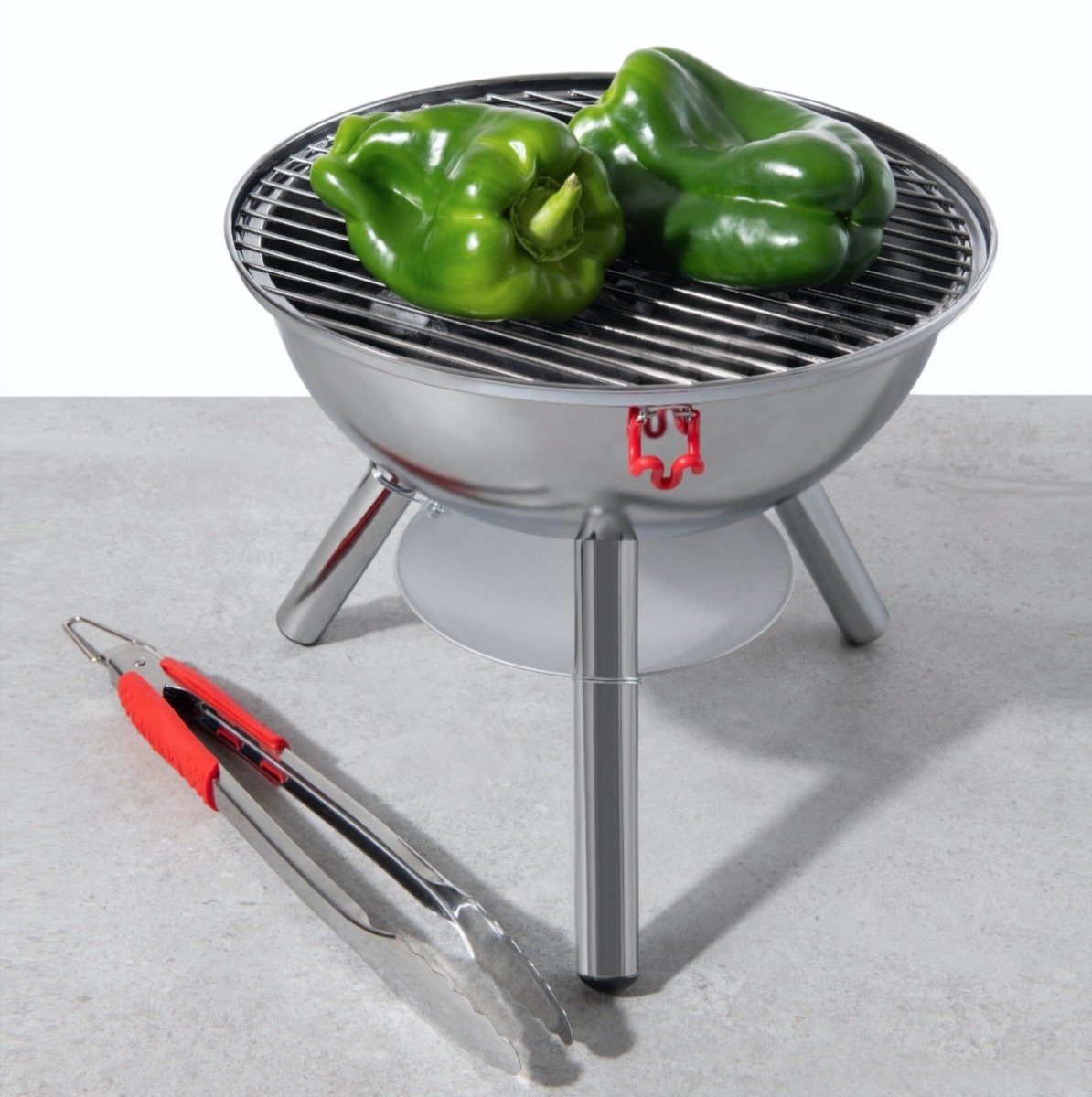 small silver grill with green pepper on it next to tongs