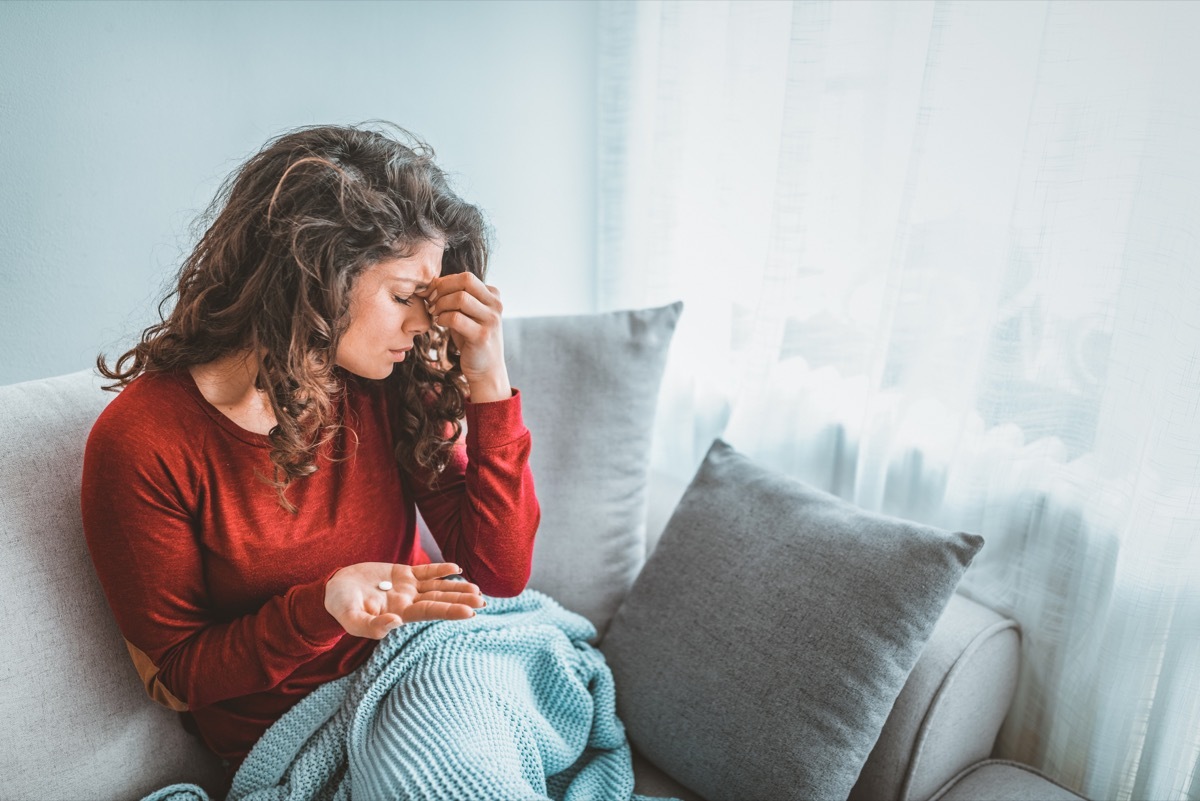 Woman Pinching Her Forehead and Taking Antidepressants