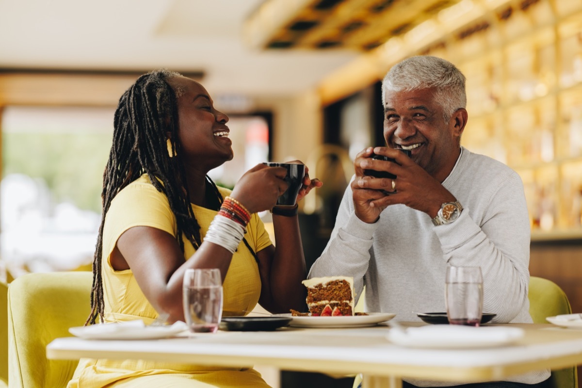 Man and woman drinking and laughing at coffee shop