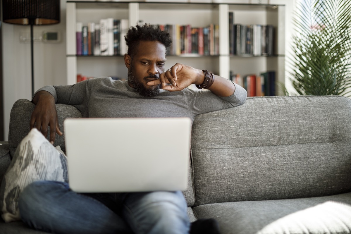 Young man watching movie on laptop at home