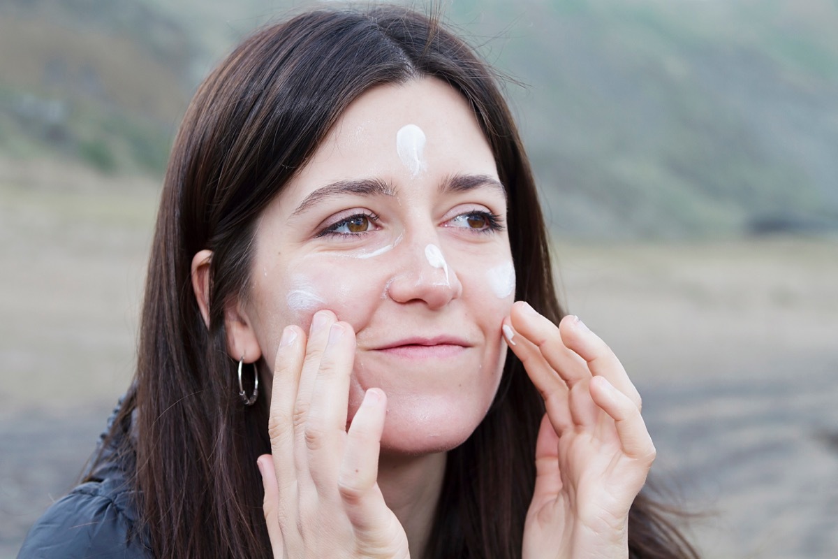 Woman applying sunscreen in the winter