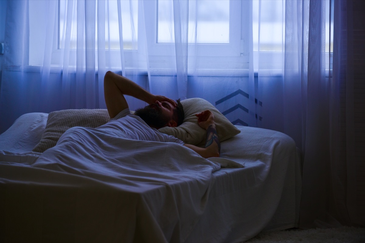 man laying in bed in his shirt