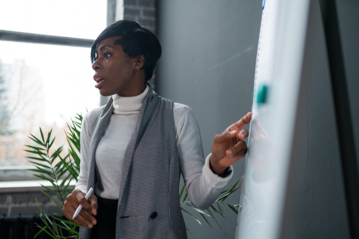 woman speaking to group using poster