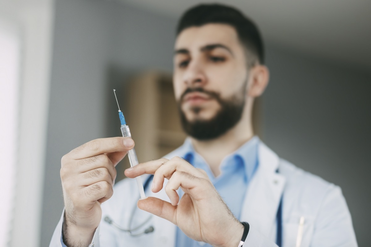 The doctor prepares for the injection with a syringe. Medical concept, close-up.