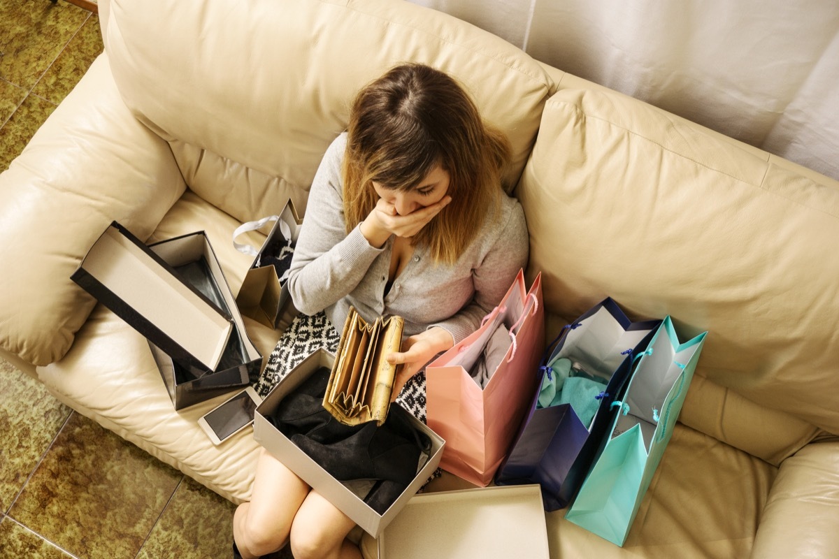 woman staring at wallet in shock