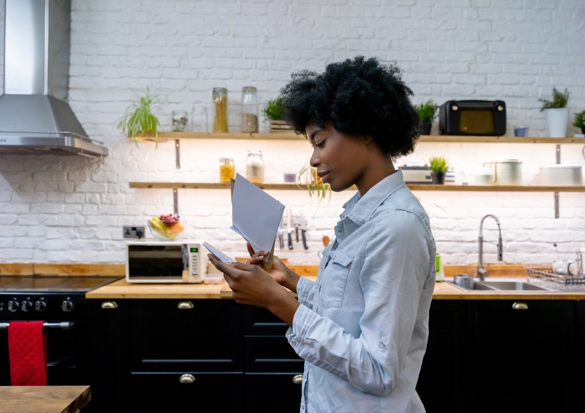 woman at home reading the mail - lifestyle concepts