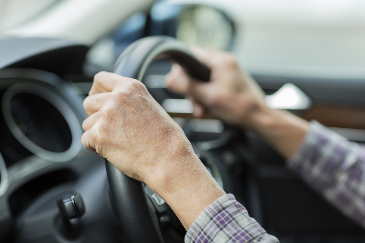 Hands on the steering wheel of a car. 