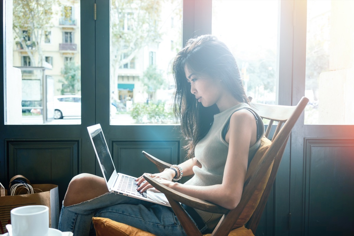 Woman on her laptop in cafe chair