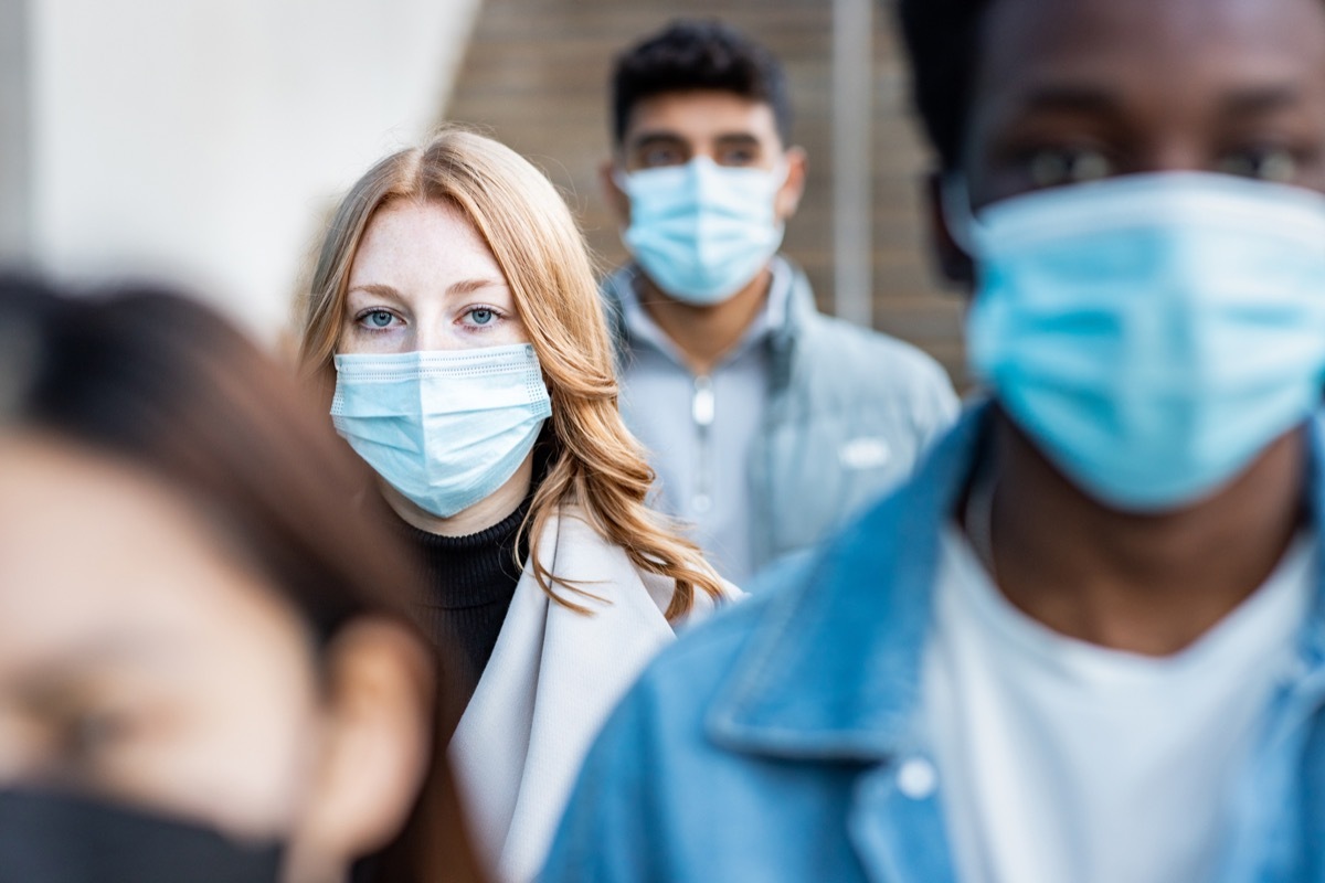 people in the city wearing face mask and walking on the pavement commuting to work - Lifestyle and health issues concepts