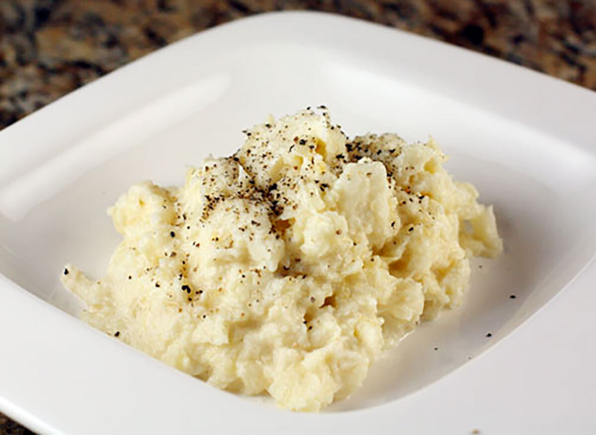 mashed root vegetables on white plate with cracked pepper