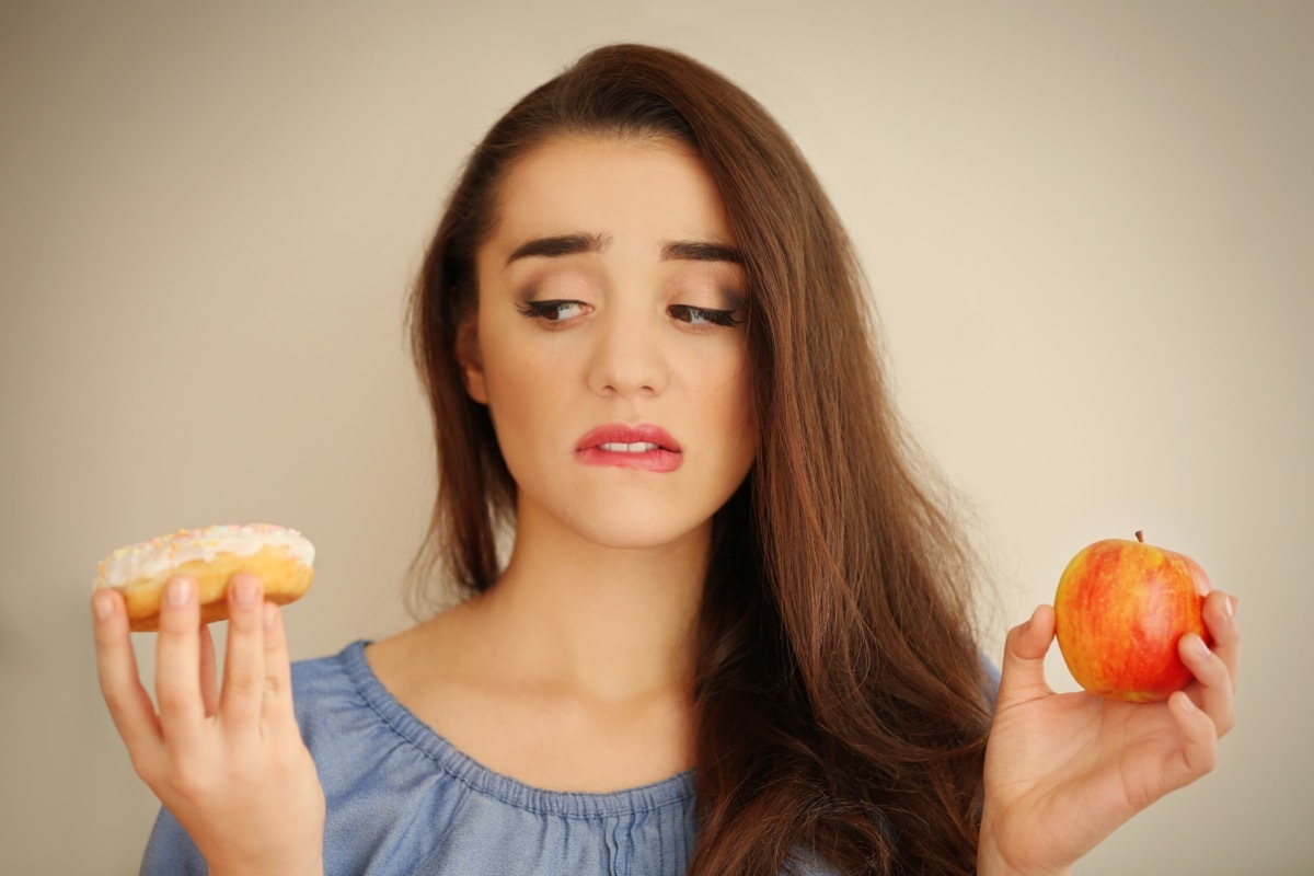 Women Holding and Apple and a Donut