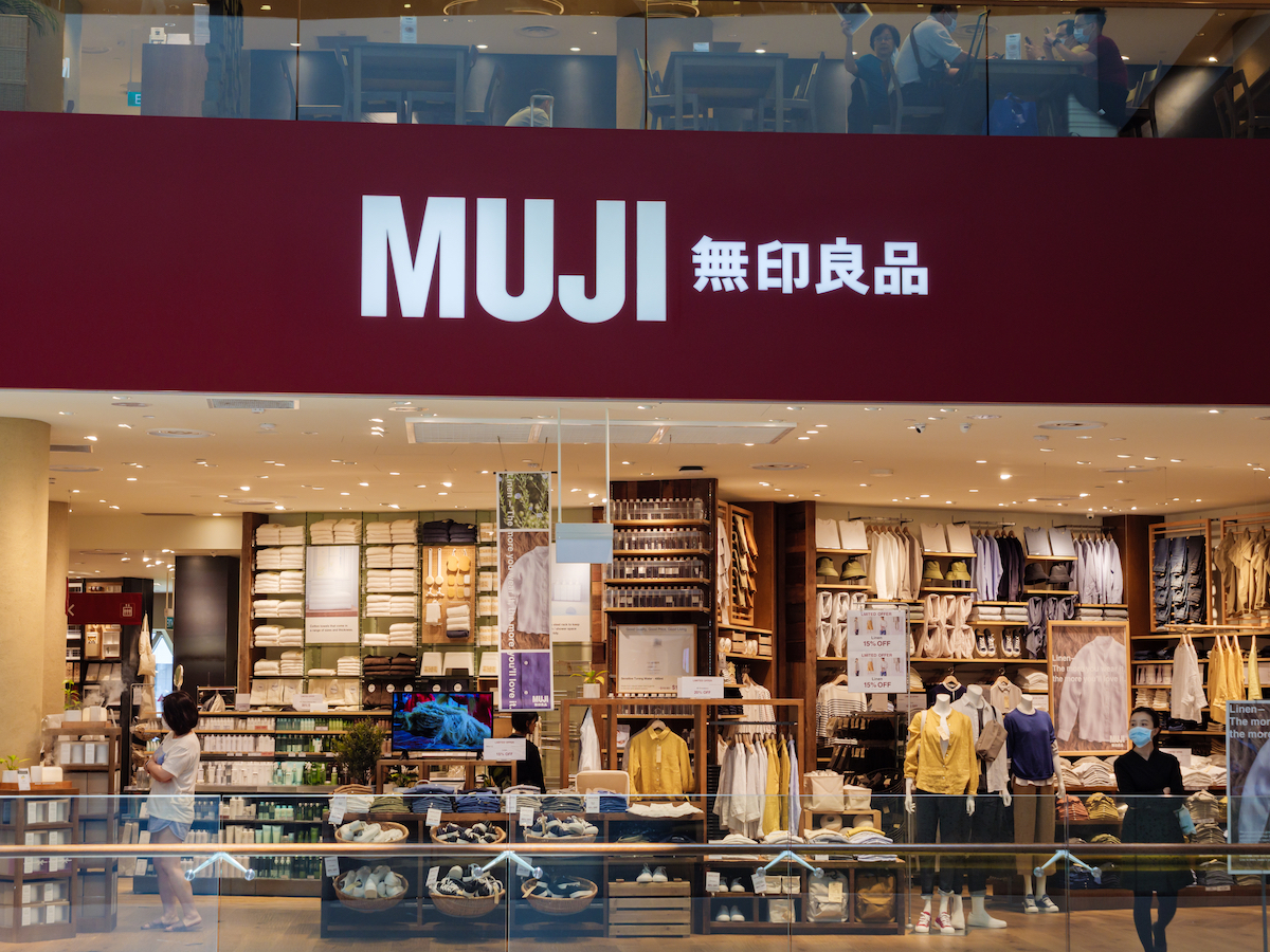 Front of a Muji store displaying clothing.