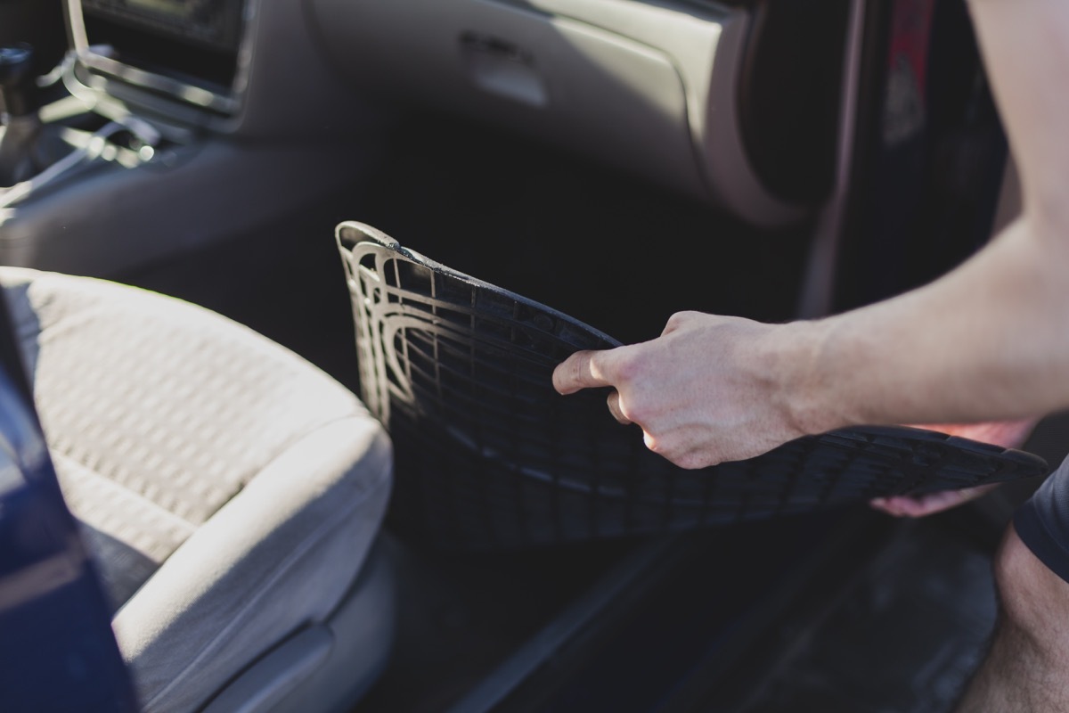 putting back floor mats after a detailed vacuuming