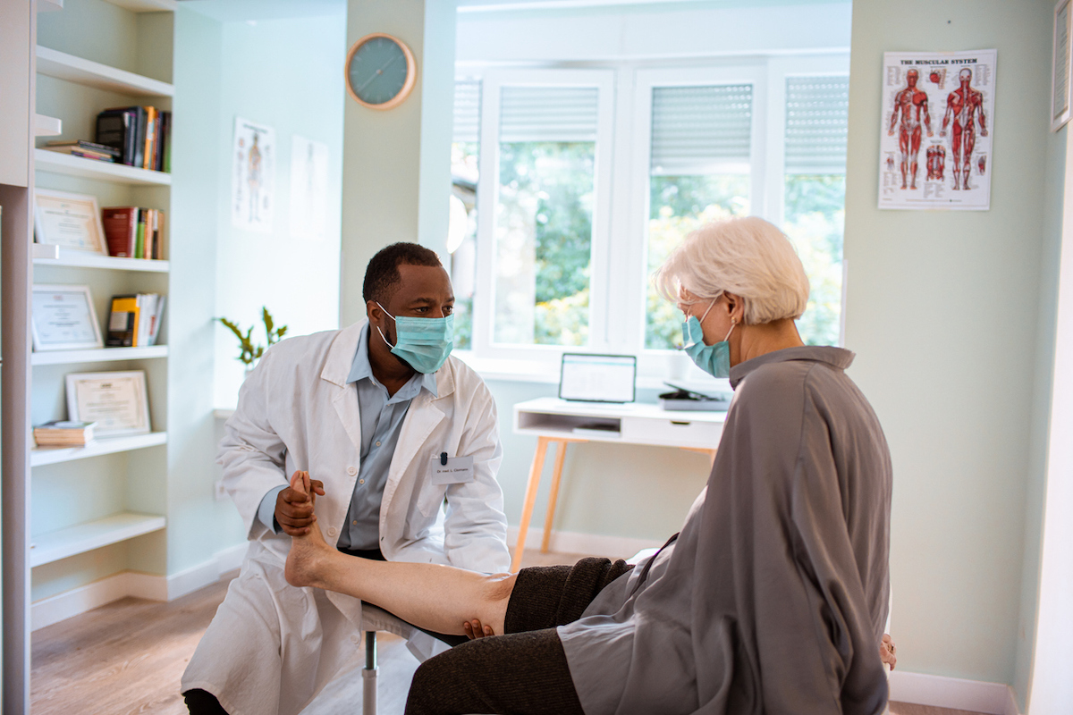 Close up of a doctor having an appointment with a patient with leg pain