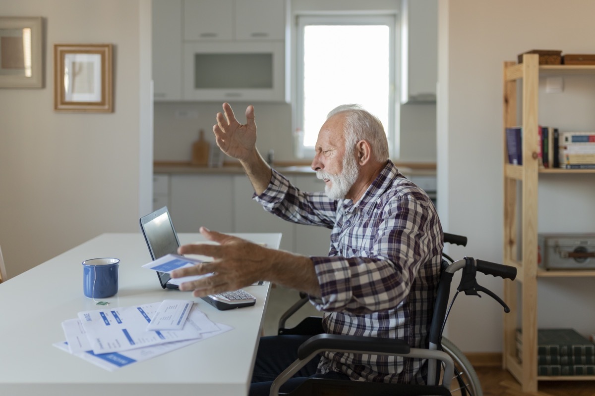 man Reading Bad News in Paper Letter Document, Troubled With Domestic Bills, Concerned About Bankruptcy Debt Money Problems. Tensed Senior Man Checking the Bills at Home While Using Laptop