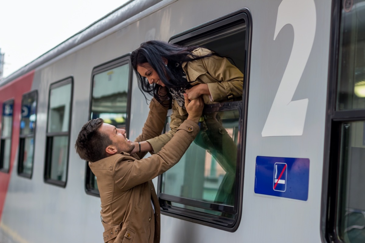 Man and woman saying goodbye through train window