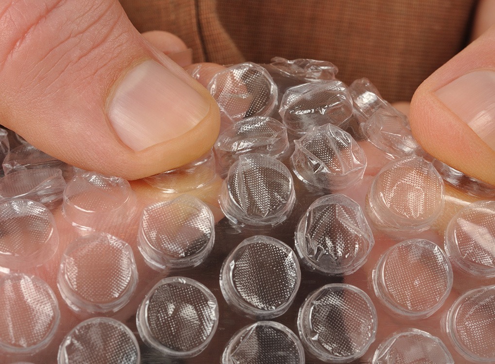 man popping bubble wrap