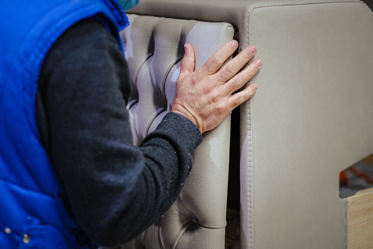 person in blue vest installing headboard