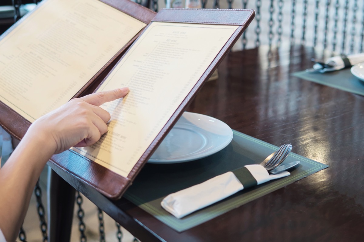 woman looking at food menu in restaurant