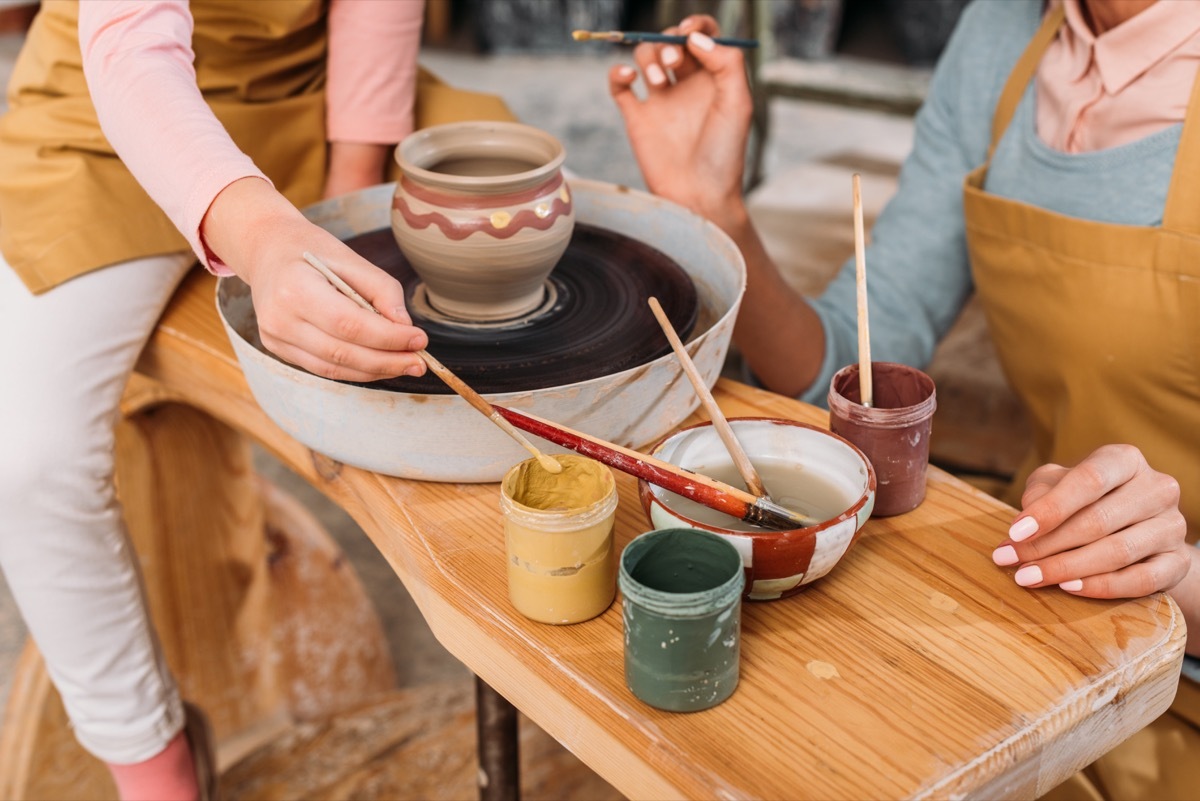 white mother and daughter making pottery