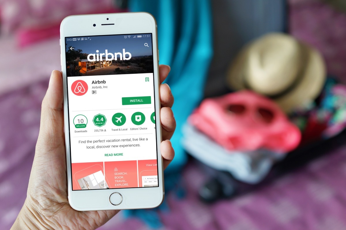 woman holding a phone with the airbnb app opened