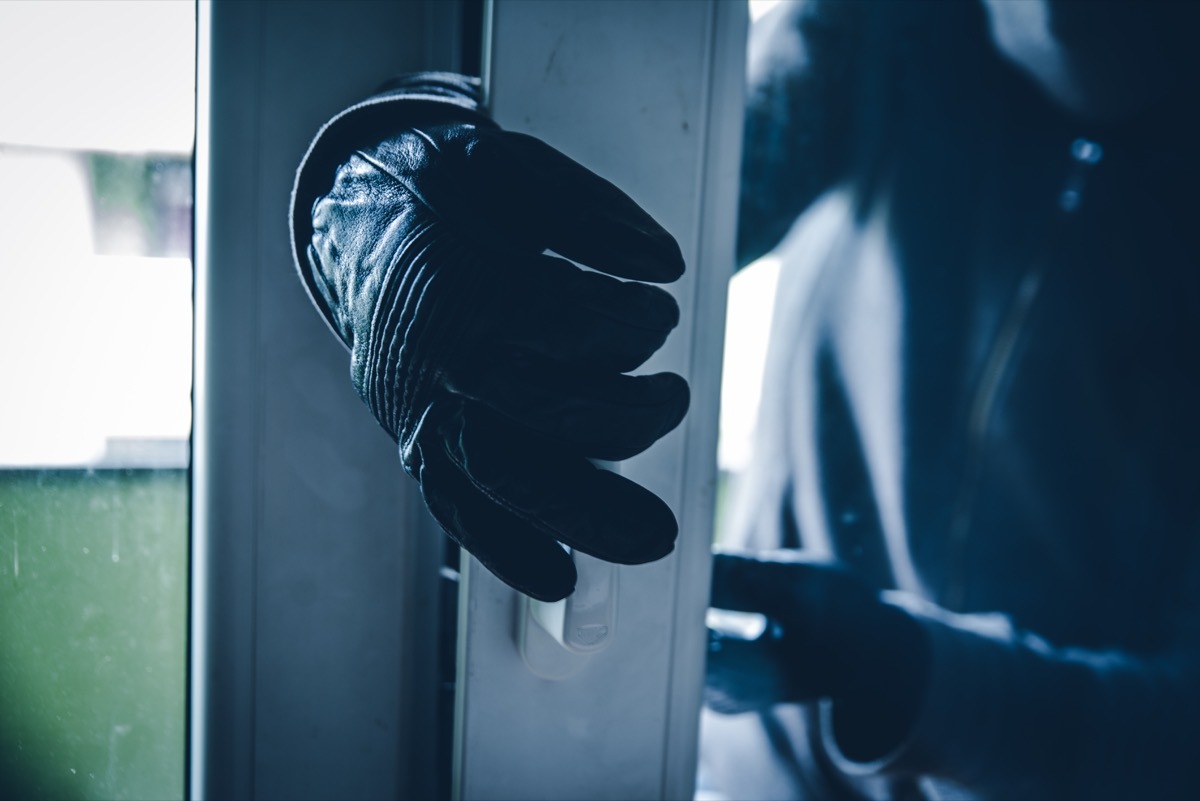 burglar breaking into home with his gloves open a door