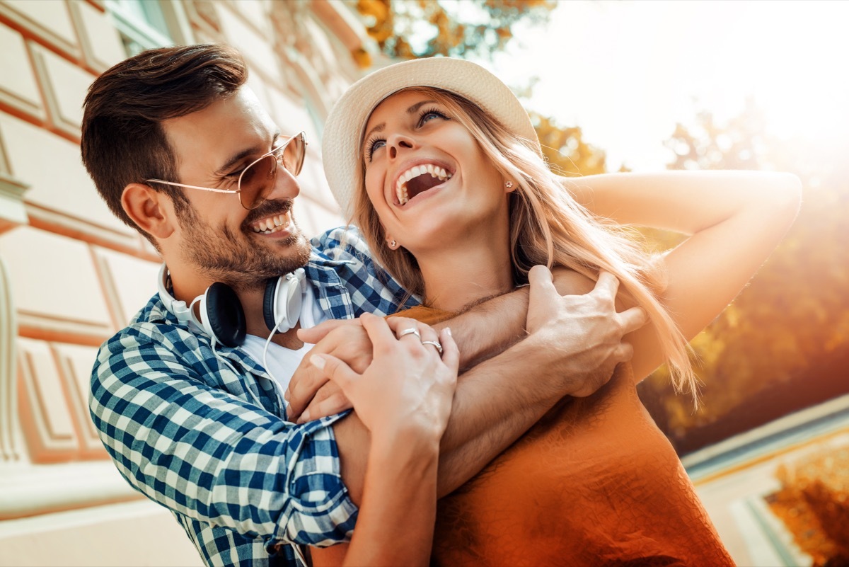 man and woman smiling and embracing outside in the sun