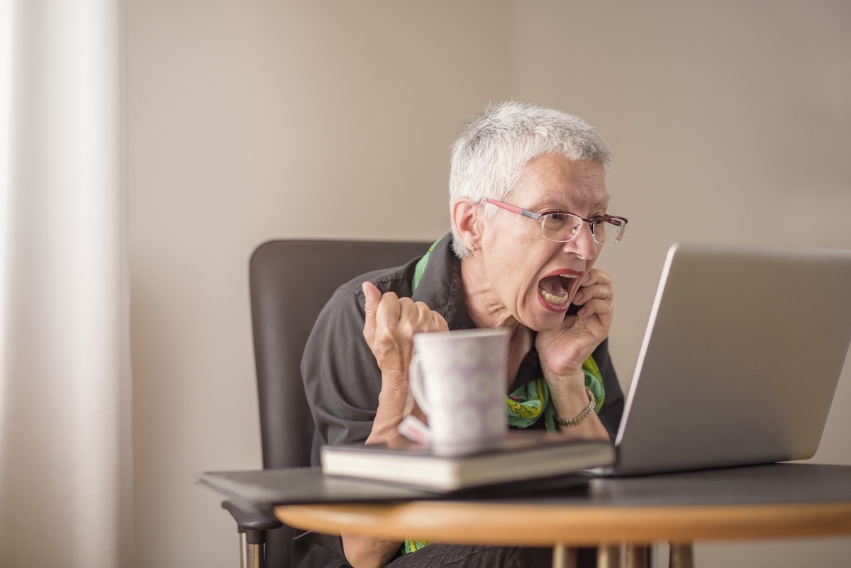 Elderly woman with white short hair and glasses screams at computer while on phone, things not to say to customer service rep