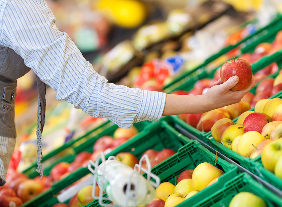 Shopper grabbing an apple at the grocery store