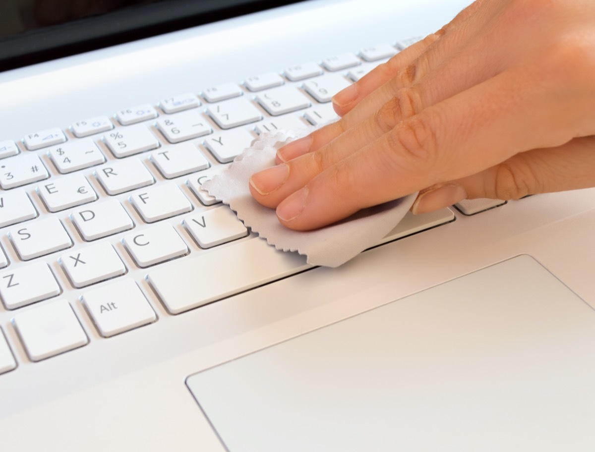 woman with a gray rag of a computer keyboard