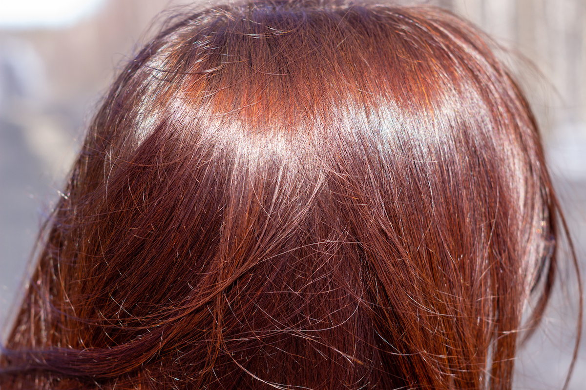 Close-up of shiny straight long auburn hair