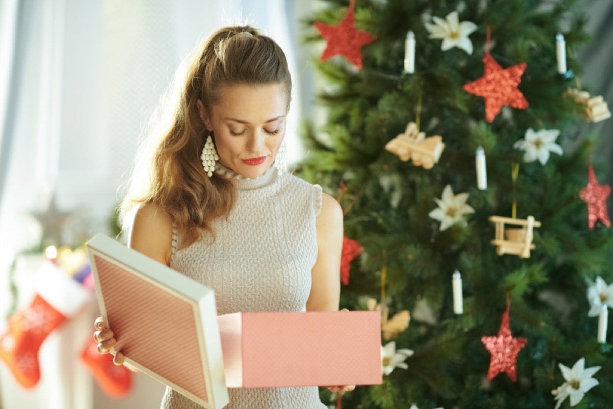 blonde woman in front of christmas tree looking upset