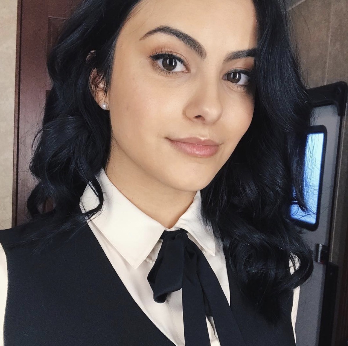 camila mendes wearing white collared shirt and black bow tie