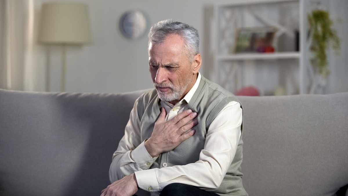 man having difficulty breathing and holding his chest