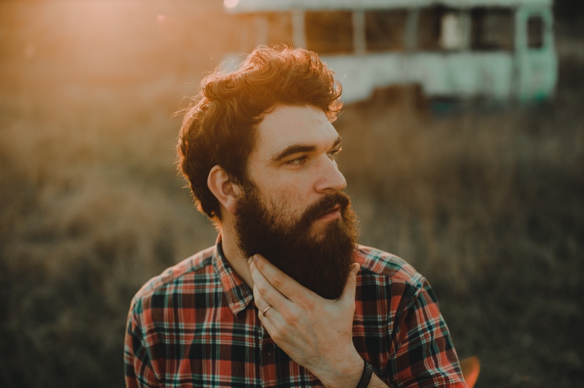 hipster man stroking his beard