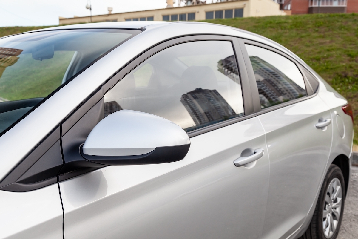 A close-up, front side-view of a silver car in a parking lot